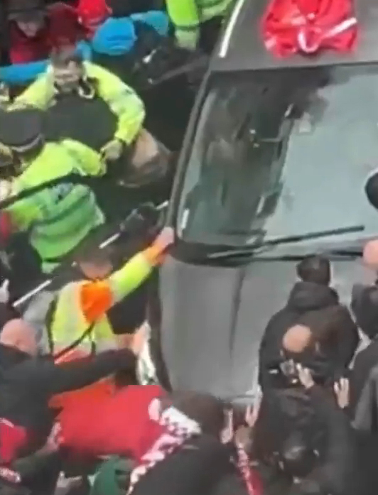 Police officers removing a driver from a car during a Liverpool parade.