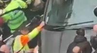 Police officers removing a driver from a car during a Liverpool parade.