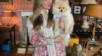 Woman in floral dress holding a Pomeranian dog.