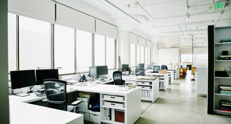 Empty office with multiple desks and computers.