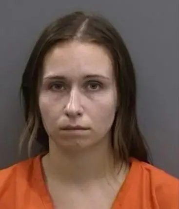 Mugshot of a woman in an orange jumpsuit.