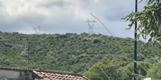 High-voltage power lines on a hillside.