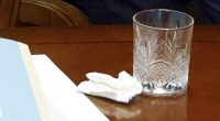 Image of a tissue, papers, and a glass on a table.