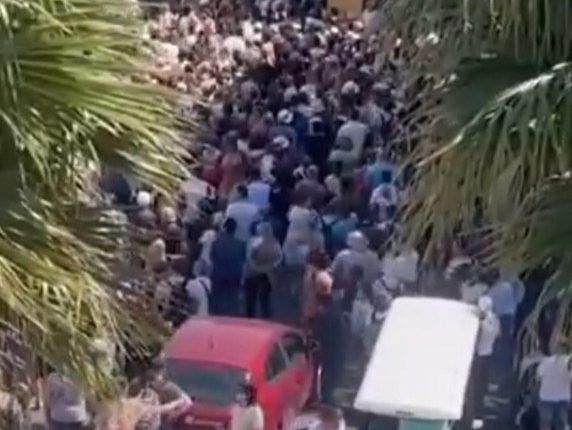 Large crowd of tourists overwhelming a narrow street in Sirmione.