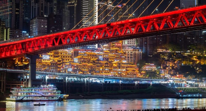CHONGQING, CHINA - APRIL 30: Tourists visit Jiangbeizui Jiangtan Park under Qiansimen Jialing River Bridge ahead of the May Day holiday on April 30, 2025 in Chongqing, China. The five-day May Day holiday will start on May 1 this year. (Photo by Fuyu Jianglin/VCG via Getty Images)