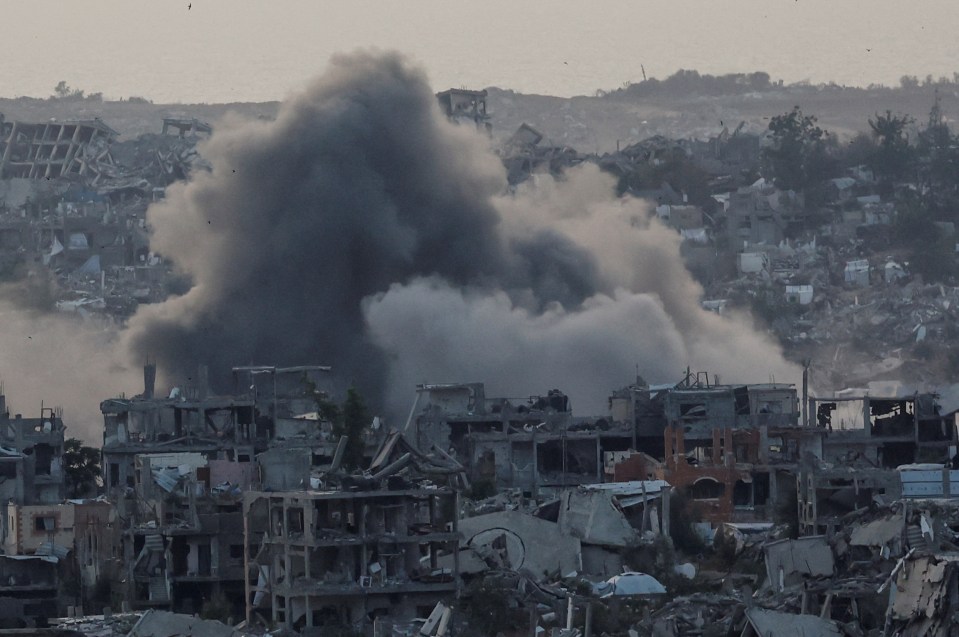 Smoke rises over destroyed buildings in Gaza following an explosion.