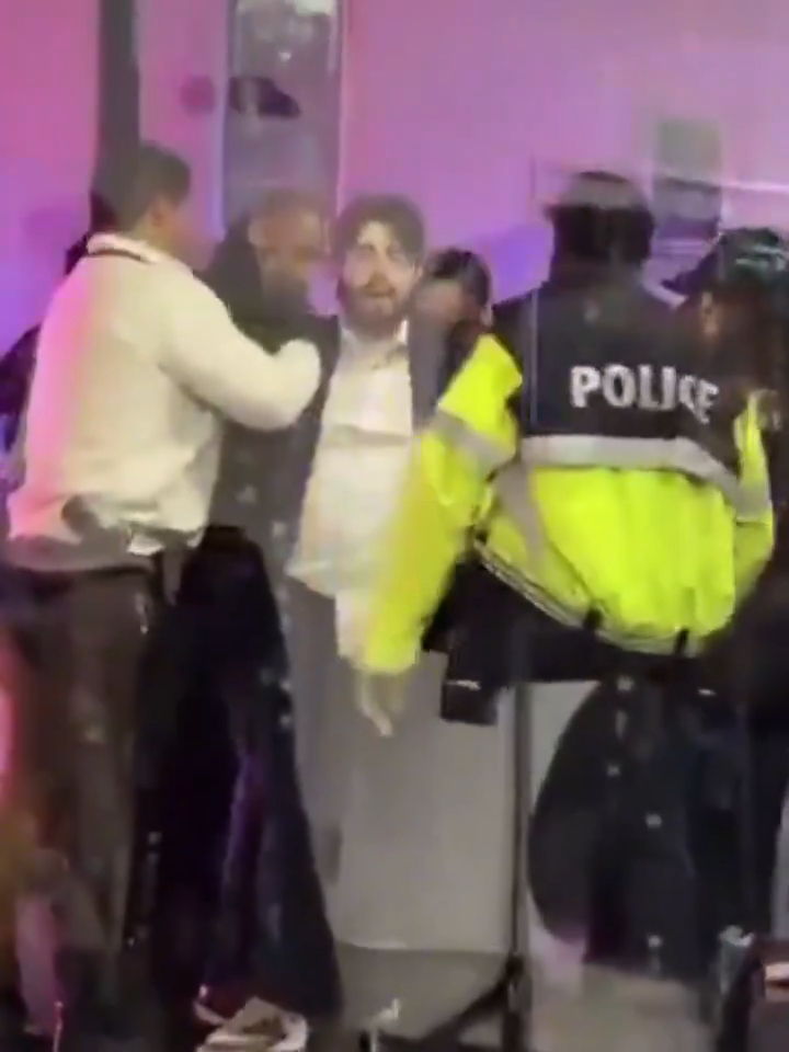 A man being detained by police officers.
