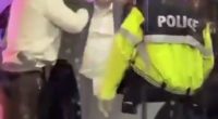 A man being detained by police officers.