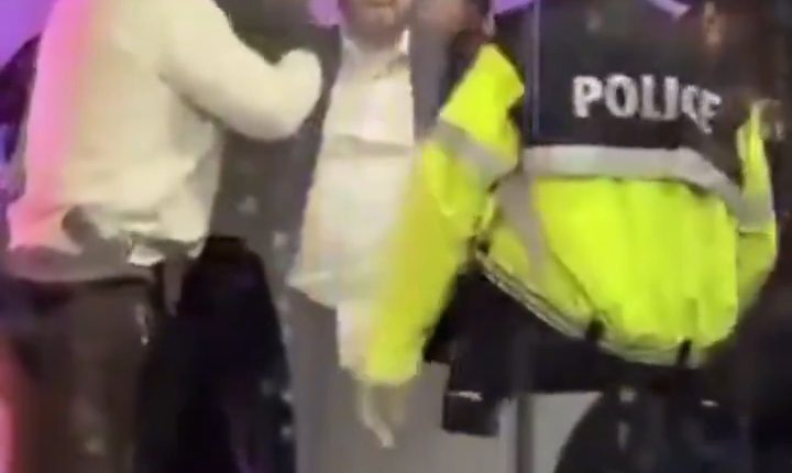 A man being detained by police officers.