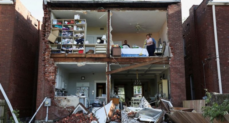 Residents surveying the damage to their tornado-destroyed home.