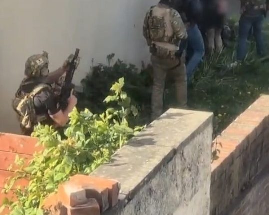 Police officers apprehending suspects.