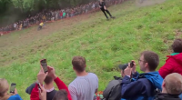 Contestant performing a somersault during a cheese rolling competition.