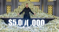 Man sitting on a large pile of money; $5,000,000 displayed.