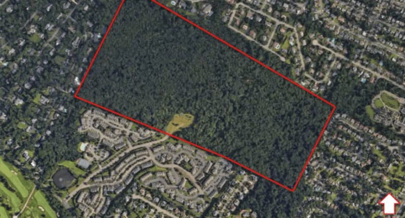Aerial view of a 120-acre plot of land proposed for a 496-unit apartment complex.