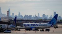 United Airlines planes at Newark International Airport with a city skyline in the background.