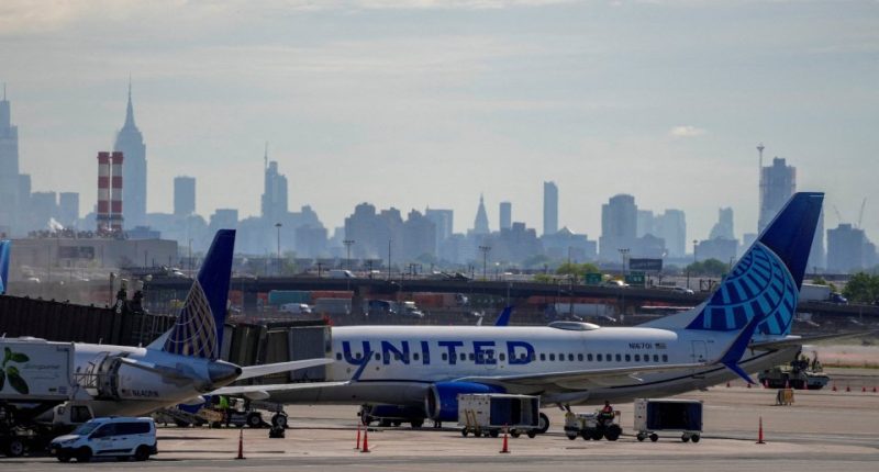 United Airlines planes at Newark International Airport with a city skyline in the background.