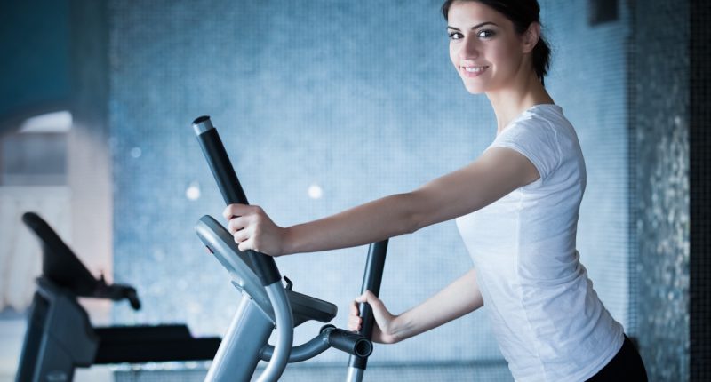 Fitness girl is working out with stepper.Strong brunette with curly hair doing aerobics on stepper.Strong young girl exercising on stepper.Woman doing fitness exercises on stepper at gymnasiumFitness girl is working out with stepper.Strong brunette with curly hair doing aerobics on stepper.Strong young girl exercising on stepper.Woman doing fitness exercises on stepper at gymnasium