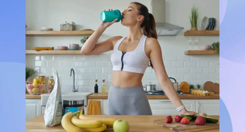 fitness woman drinking a protein shake in bright kitchen