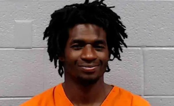 Mugshot of a man in an orange jumpsuit.