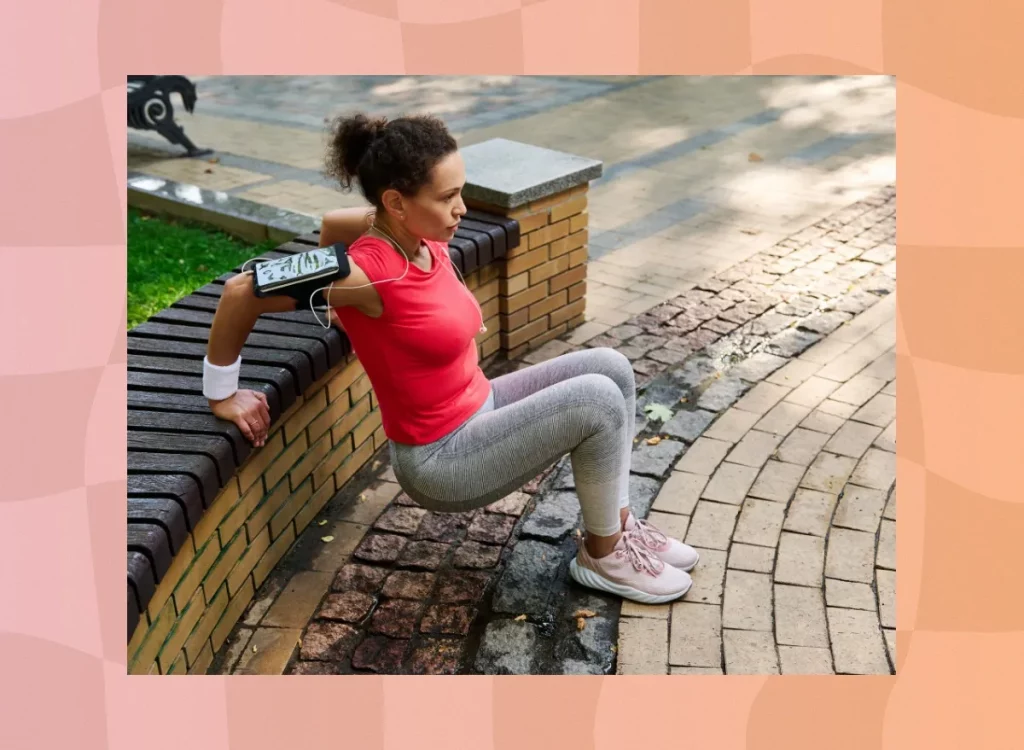 middle-aged woman doing tricep dips on wall at park