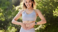 Fitness, heart hands and portrait of runner woman outdoor in park for summer training or workout. Gut health, improvement and wellness with happy sports athlete running in nature for cardio exercise