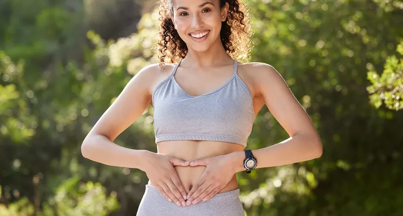 Fitness, heart hands and portrait of runner woman outdoor in park for summer training or workout. Gut health, improvement and wellness with happy sports athlete running in nature for cardio exercise