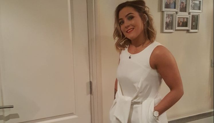 Woman in white jumpsuit and gold heels.