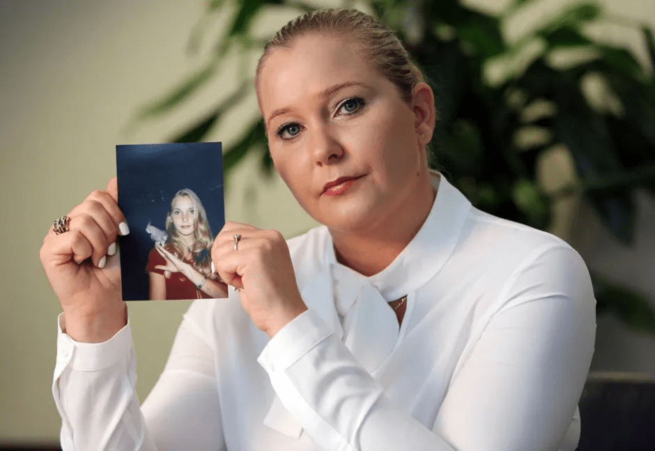 Woman holding a photograph of a younger woman.