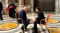 Donald Trump and another man sitting in chairs facing each other.