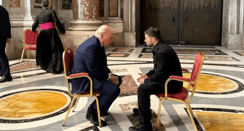 Donald Trump and another man sitting in chairs facing each other.