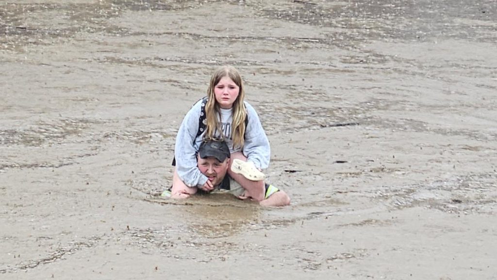 Dad carries 9-year-old daughter on shoulders through Westernport flood waters