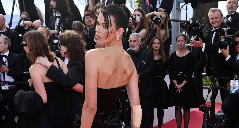 Georgia Fowler sports a plaster on her arm as she storms red carpet in a sparkling black gown for The History Of Sound premiere at Cannes Film Festival