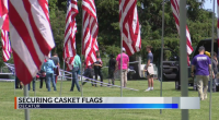 Three Decatur men protecting casket flags at cemetery