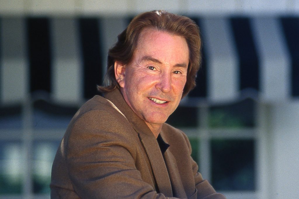 Ty Warner smiles in a brown suit jacket.