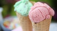 Two ice cream cones, one strawberry and one mint.