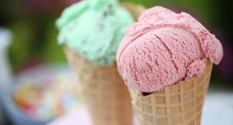 Two ice cream cones, one strawberry and one mint.