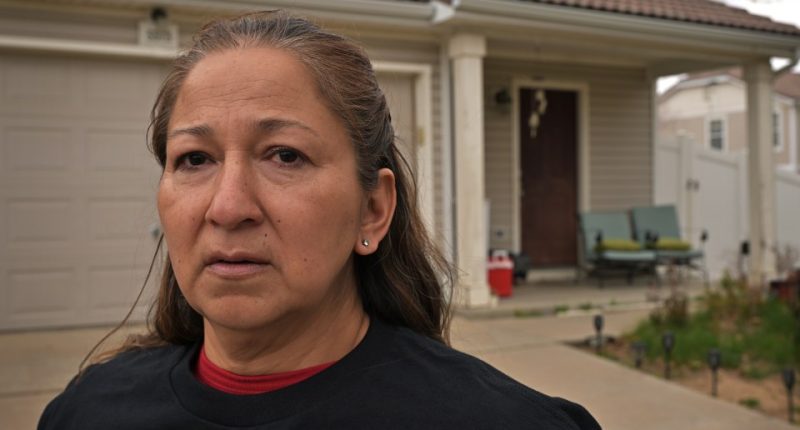 Woman standing in front of her home.