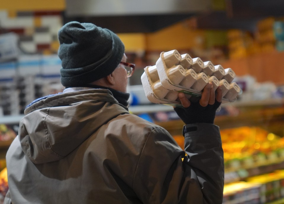 Person holding a carton of eggs in a supermarket.