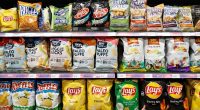 SELANGOR, MALAYSIA - 27 FEB 2022. Various imported brands of flavoured chips and snacks on store shelf in Village Grocer store. Village Grocer is the coolest fresh premium supermarket in Malaysia.