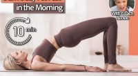 8 Morning Moves Women Over 40 Should Do To Burn Belly Fat Fast, Cover, Attractive blonde woman in sports beige leggings and tank top, practicing yoga, doing Glute bridge exercise, dvi pada pithasana pose, home workout. Coach Renee