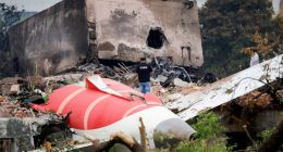 Fire officer surveying the wreckage of a crashed Air India Boeing 787-8 Dreamliner.