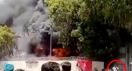 Footage of a man calmly walking away from a large fire.