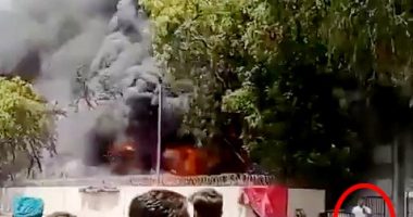 Footage of a man calmly walking away from a large fire.