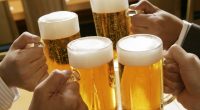 Four people toasting with beer.