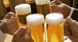 Four people toasting with beer.