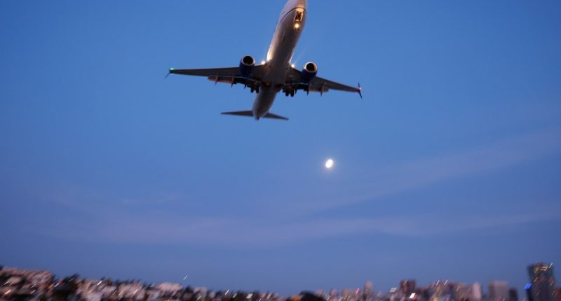 Boeing 737 approaching San Diego International Airport at sunset.
