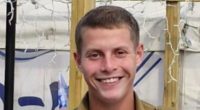 Portrait of a smiling young man in a military uniform.