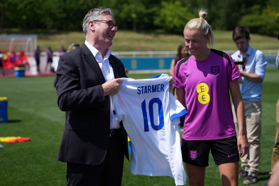 Keir Starmer presents an England football jersey to a member of the Lionesses.