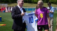 Keir Starmer presents an England football jersey to a member of the Lionesses.