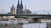 Cologne Cathedral and a bridge over the Rhine River, with a security perimeter in the foreground.